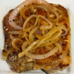 Grilled pork chops, marinated in a blend of garlic and lime, topped with sautéed mojo onions