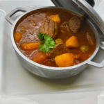 Chunks of beef and potatoes in tomato sauce, garlic, onions, bell peppers